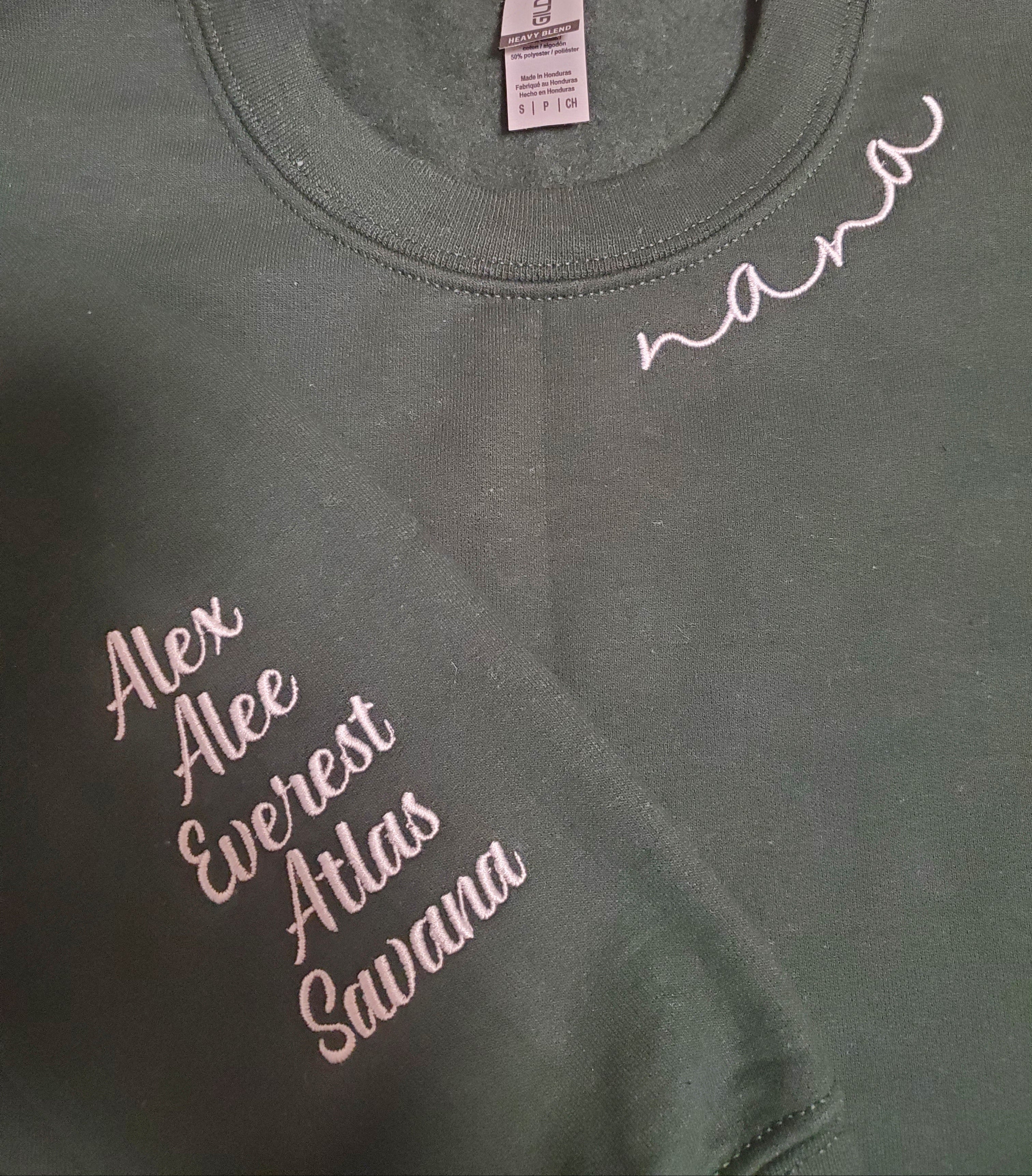 Green t-shirt with embroidered names on a grid background
